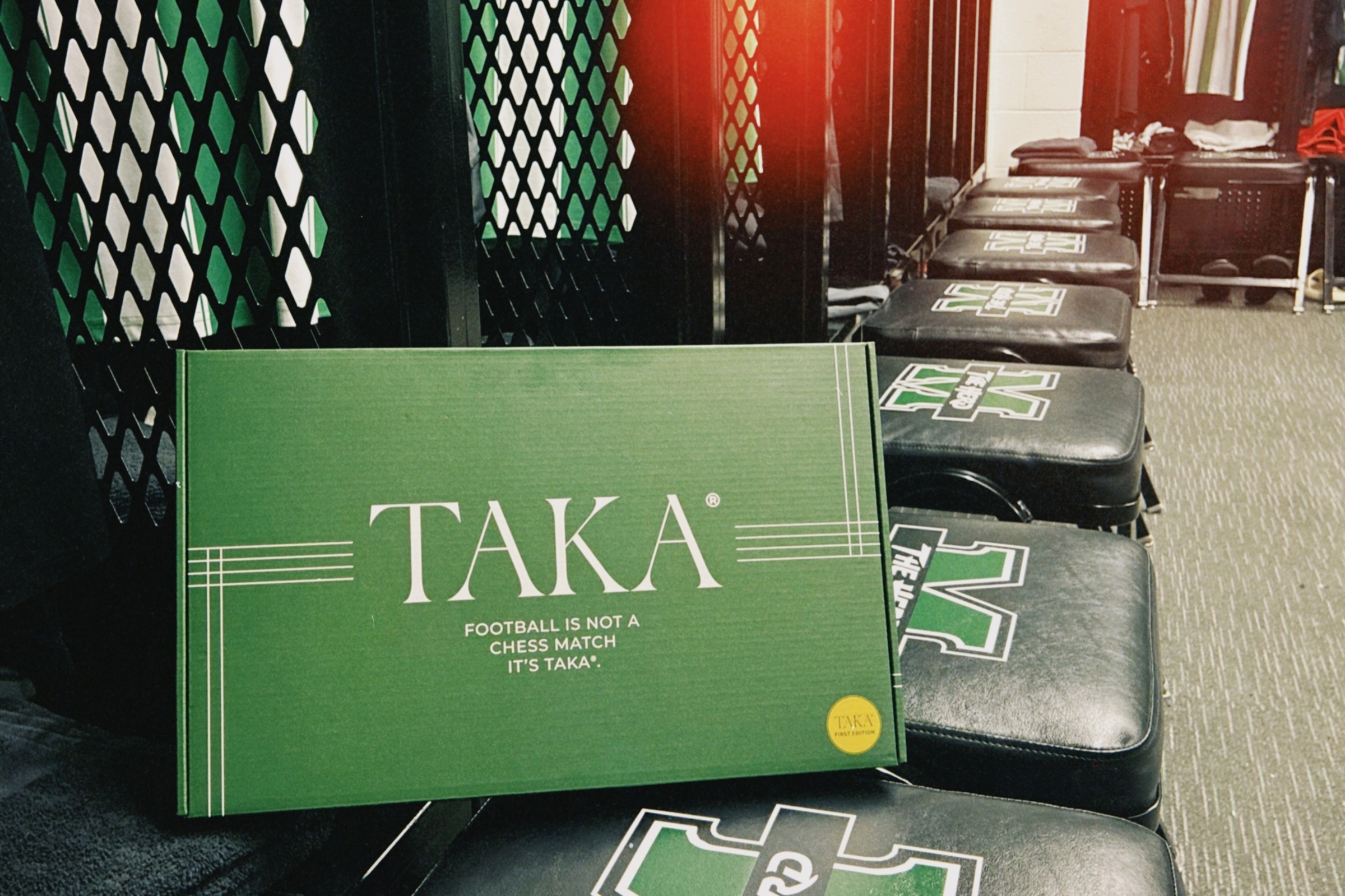 TAKA first-edition box propped on the Marshall locker-room benches